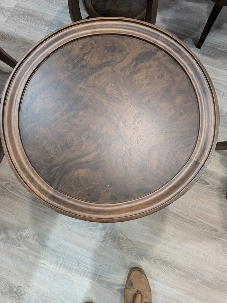 Top view of a round table with a burl walnut center inside a molded solid walnut ring