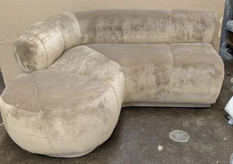 Curved champagne velvet sofa with a rounded end, in the workshop