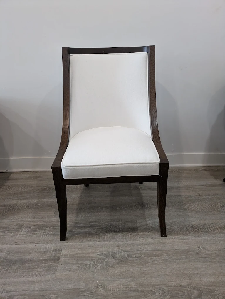 Upholstered dining chair with a dark walnut frame and ivory seat