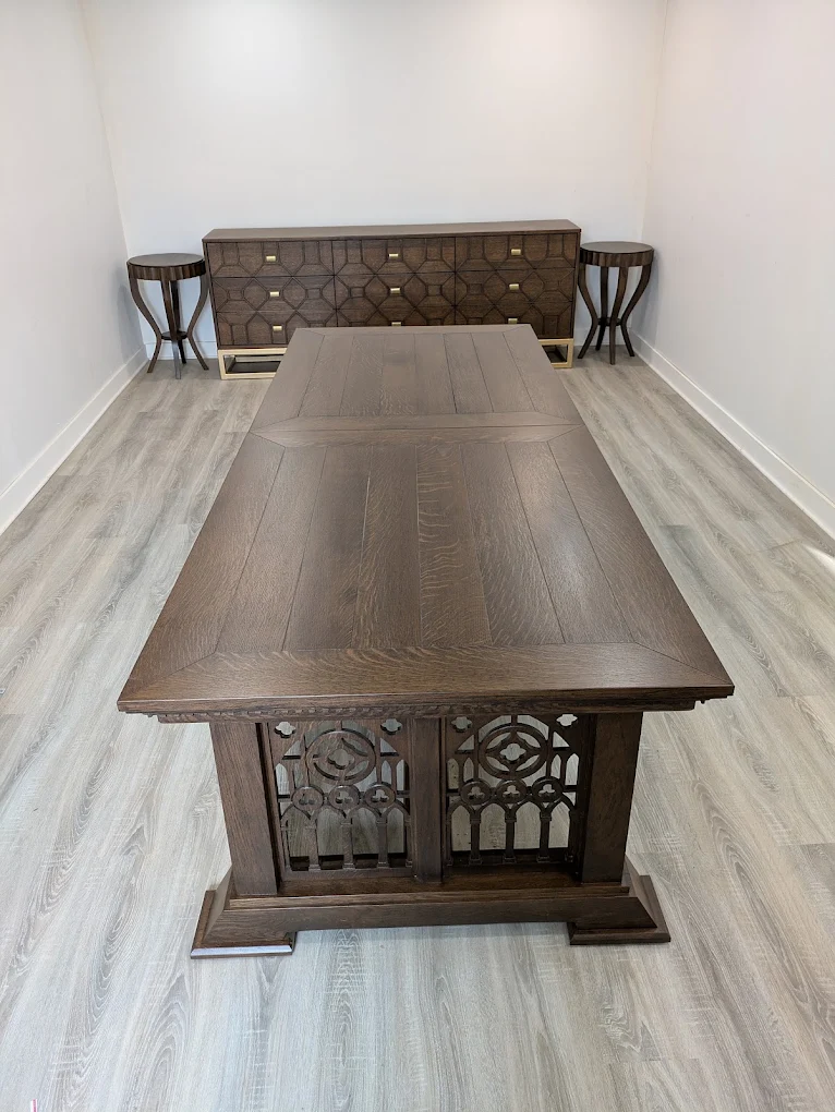 Long oak trestle dining table with carved Gothic tracery panels, with matching sideboard and side tables behind