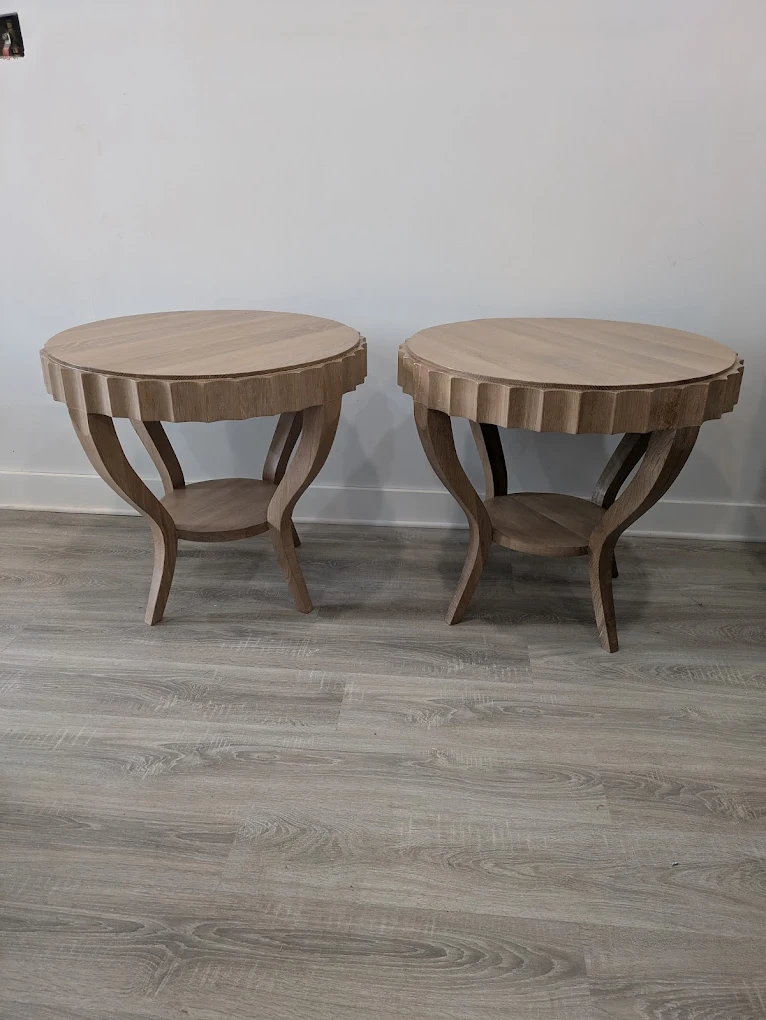 Matching pair of light oak round end tables with fluted rims, curved legs and a lower shelf