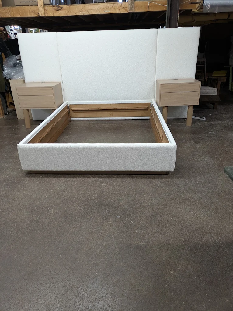 White upholstered panel bed with a wide headboard and floating nightstands